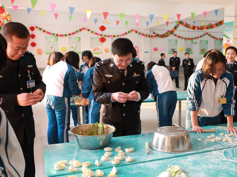 （用）省司法廳戒毒管理局局長段劍平（中）同干警、戒毒學(xué)員一起包餃子。