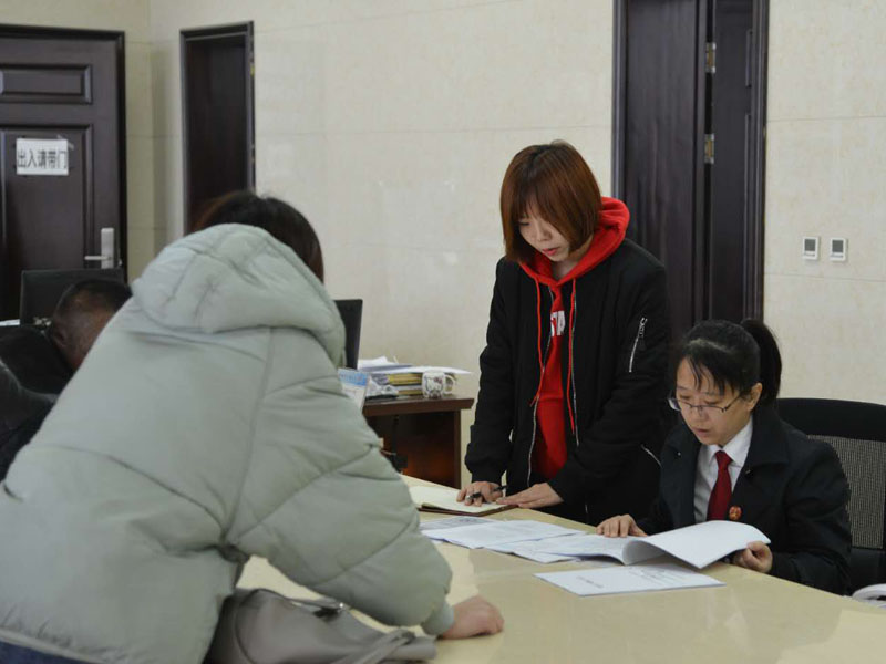 圖四，記者和劉璐一起在立案窗口接待辦事人