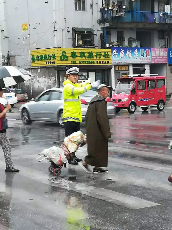 交警邊指揮交通邊幫助老人過馬路