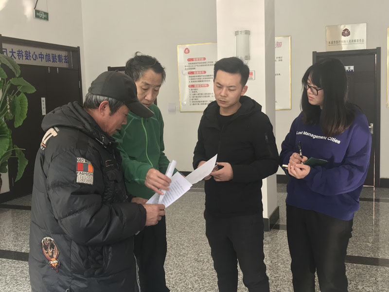記者（右一）同中心工作人員為來申請法律援助的市民進(jìn)行服務(wù)