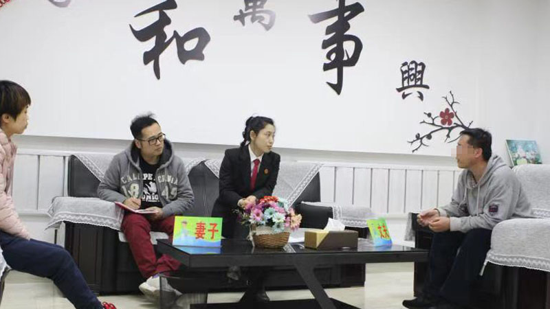 記者（左二）與法官?gòu)垪钤诩沂抡{(diào)解室中開導(dǎo)夫妻二人
