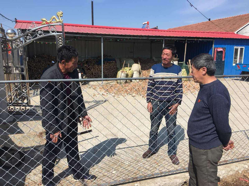 潘文財(cái)（左一）正在村民家中調(diào)解