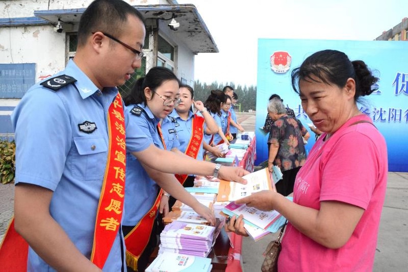 法治宣傳志愿者向市民發(fā)放宣傳手冊(cè)