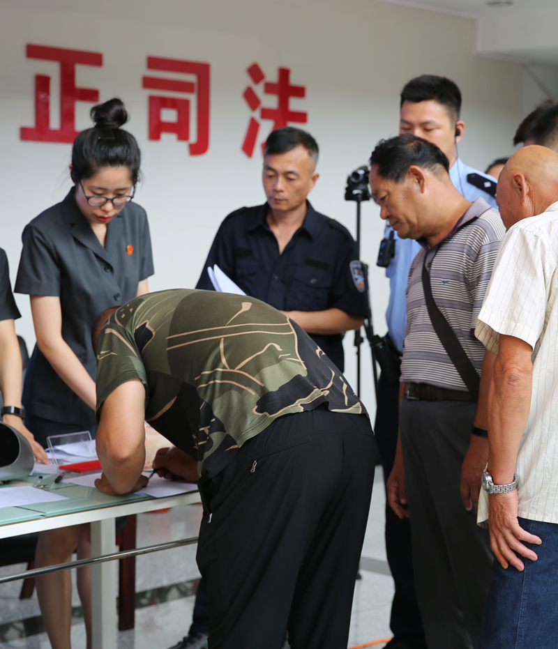 農(nóng)民工們正在東洲區(qū)法院法官干警的有序指導下領回自己的血汗錢