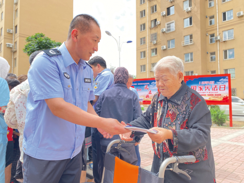 唐兵向?qū)O秀梅老人發(fā)法治宣傳手冊1