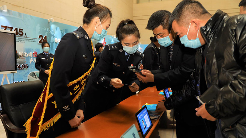 民警指導(dǎo)市民掃碼登錄“交管12123”APP。