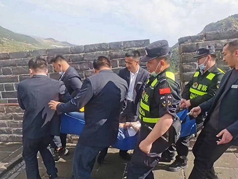 民警與景區(qū)工作人員將患病游客抬下長(zhǎng)城。