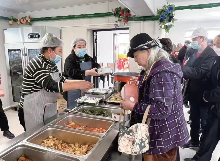 配文1：社區(qū)居民在食堂打飯。