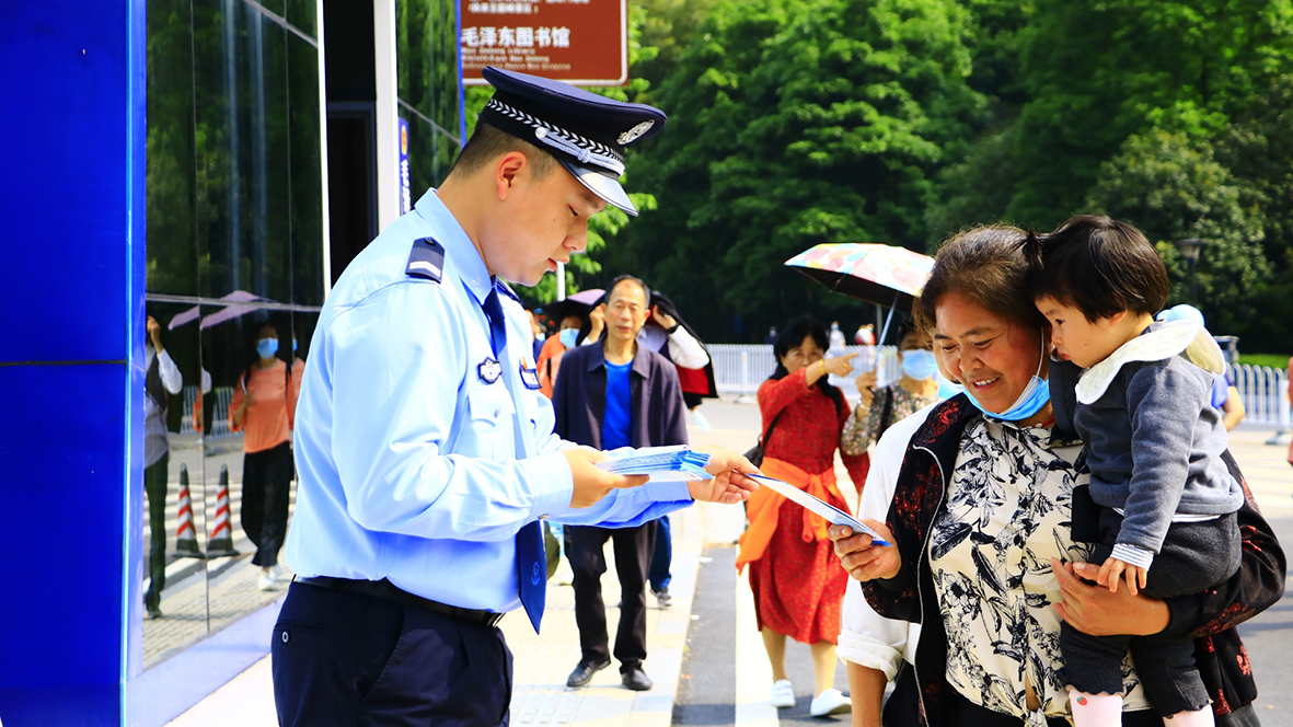 韶山?jīng)_派出所，民警向游客發(fā)放反詐宣傳單