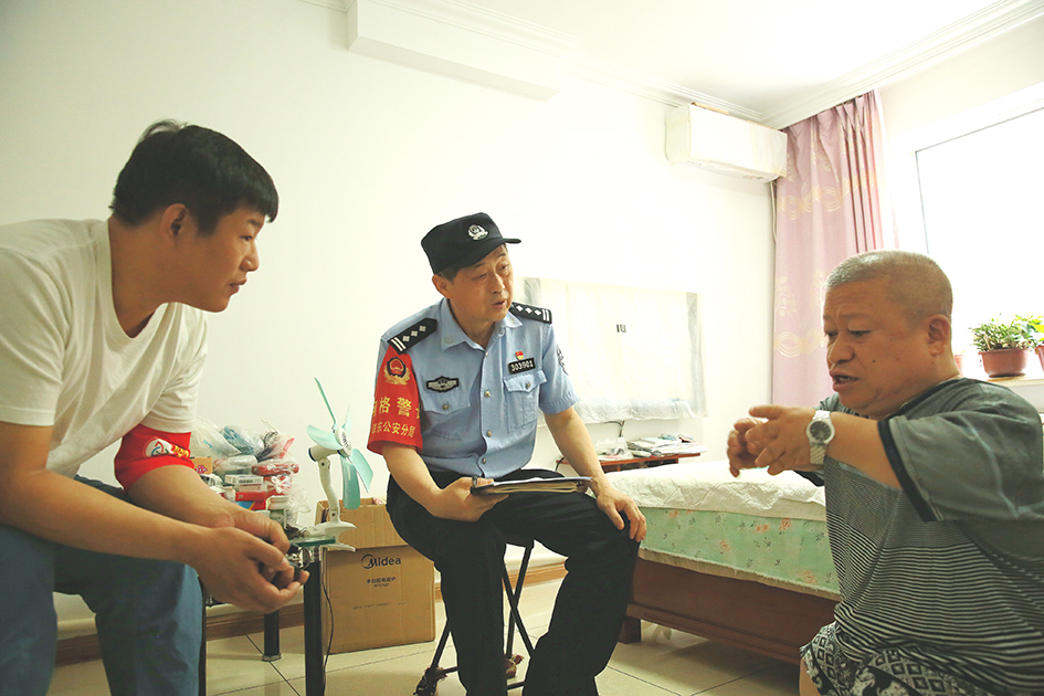 臨退休前，社區(qū)民警王忠利（左二）和網(wǎng)格員去劉學成家中走訪