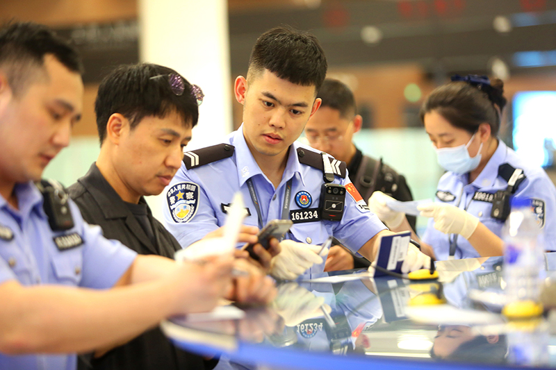民警協(xié)助外國旅客填寫入境卡片。