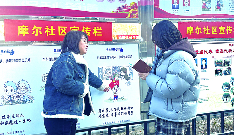 薛娜向記者介紹法治漫畫(huà)普法宣傳欄 孟浩攝