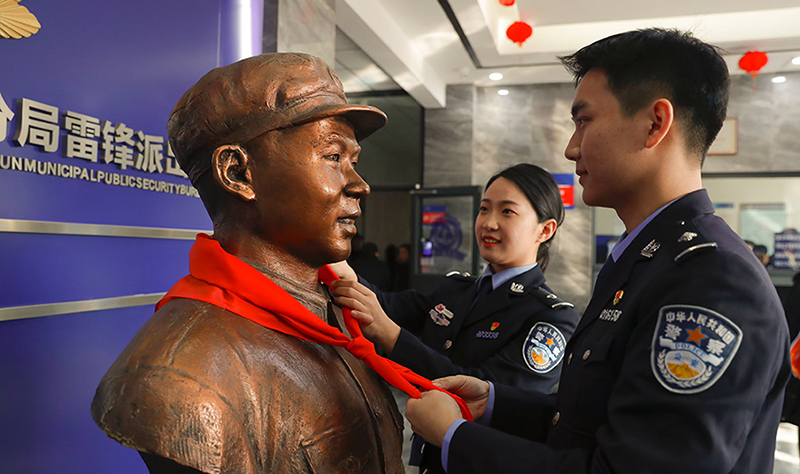 2024年3月5日，撫順市公安局望花分局雷鋒派出所民警白靜（右）和長沙市公安局雷鋒派出所民警韓政霖（左）共同為雷鋒塑像整理紅領巾。
