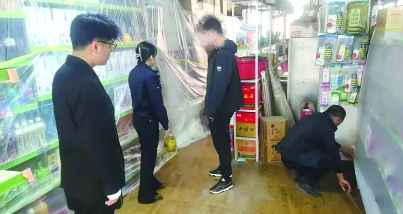 二圖，法院干警正在幫助一樓商戶粘貼防塵塑料布